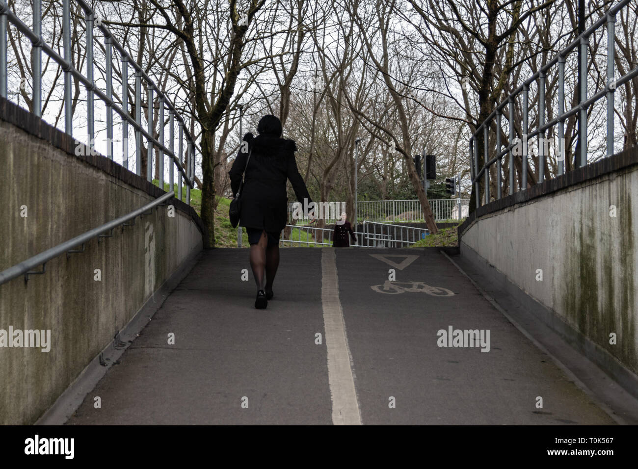 Dame gehen unter der U-Bahn oder Unterführung in Großbritannien Stockfoto