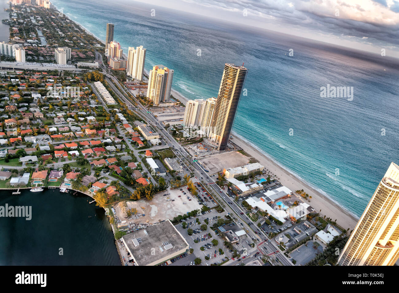 Beeindruckende Skyline von Miami Beach. Luftaufnahme der städtischen Gebäude und den See von Hubschrauber an einem bewölkten Sonnenuntergang. Stockfoto