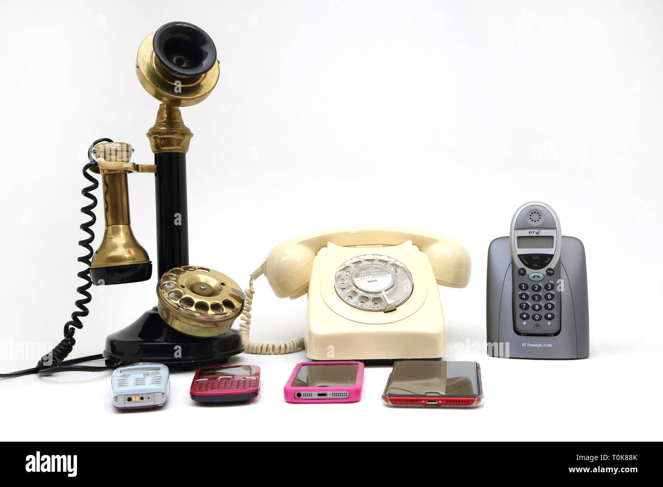 Eine Sammlung von Telefonen, die Alten und Neuen - Leuchter Telefon, Drehschalter Telefon, schnurloses Telefon und Handys - Nokia 3310, Nokia C3, iPhone 5 Stockfoto
