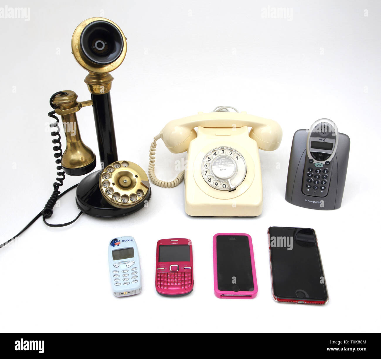 Eine Sammlung von Telefonen, die Alten und Neuen - Leuchter Telefon, Drehschalter Telefon, schnurloses Telefon und Handys - Nokia 3310, Nokia C3, iPhone 5 Stockfoto