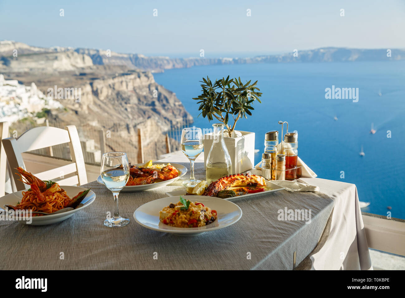 Ein Abendessen für Zwei mit Fisch und Wein, eine Tabelle auf dem Hintergrund des Meeres Stockfoto