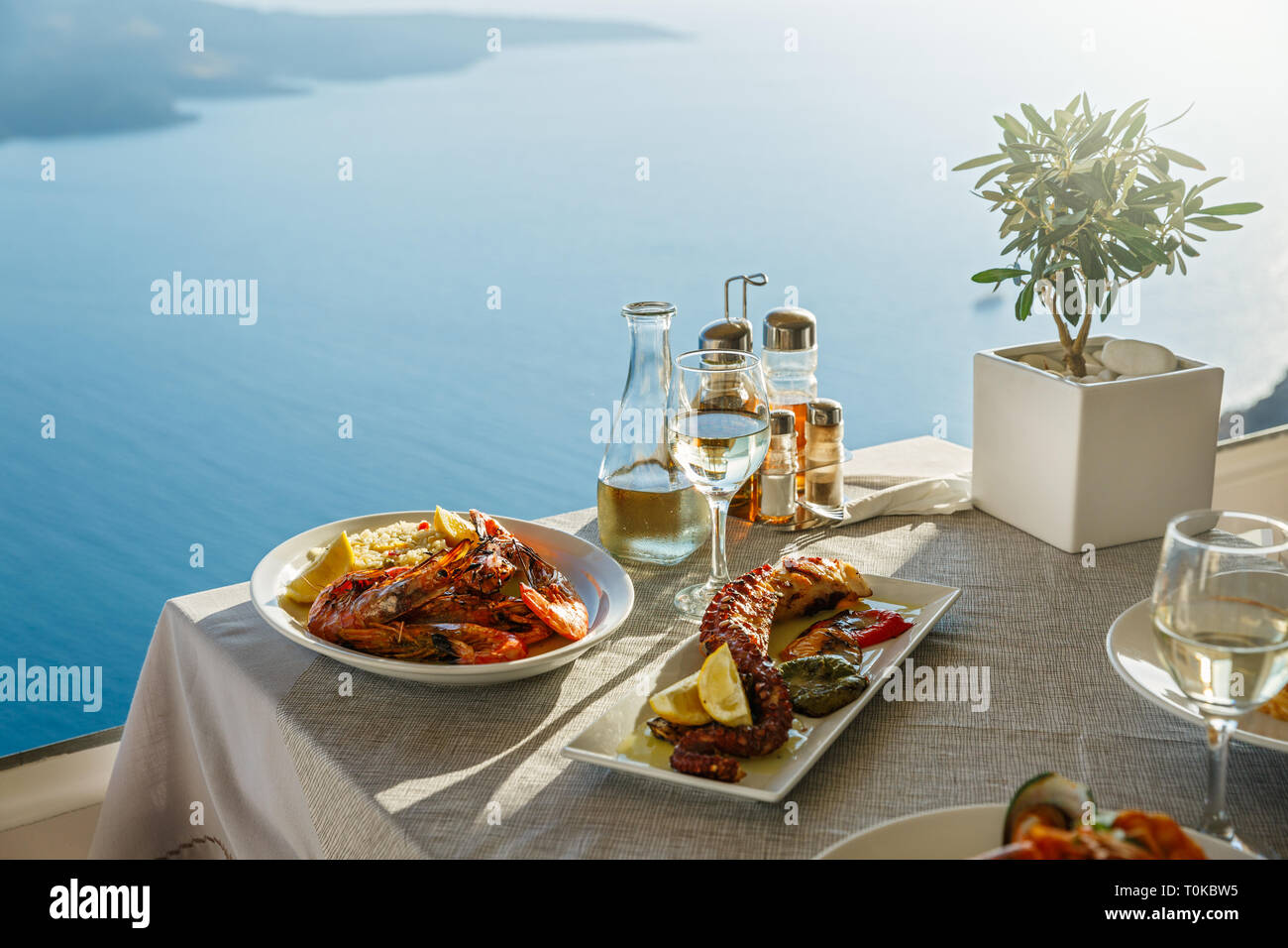 Ein Abendessen für Zwei mit Fisch und Wein, eine Tabelle auf dem Hintergrund des Meeres Stockfoto