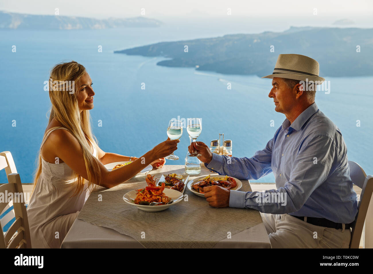 Mann und Frau, Abendessen in einem Restaurant, auf dem Hintergrund der Meer, Insel Santorini, Griechenland Stockfoto