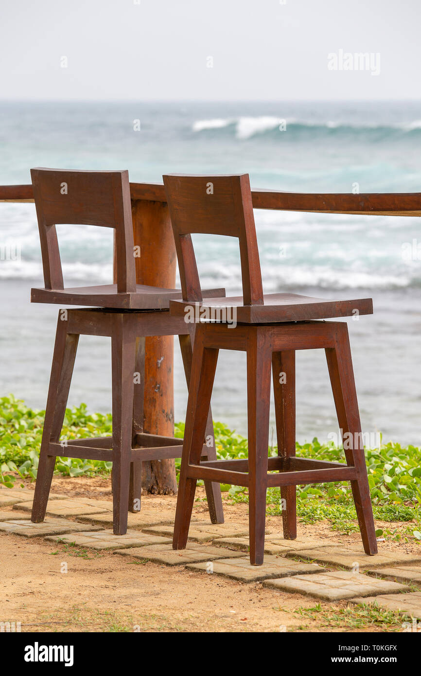 Hölzerne Stühle und Tisch in leeren Café neben dem Meerwasser am tropischen Strand, Sri Lanka. Nahaufnahme Stockfoto