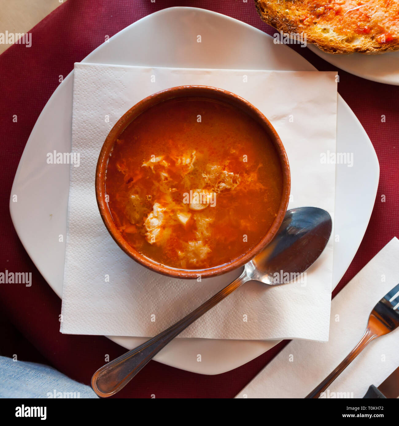 Ansicht von oben Ton Schüssel des Kastilischen Knoblauch Suppe mit Brot, stringy Ei und druckvolle Brühe. Spanische Küche Stockfoto