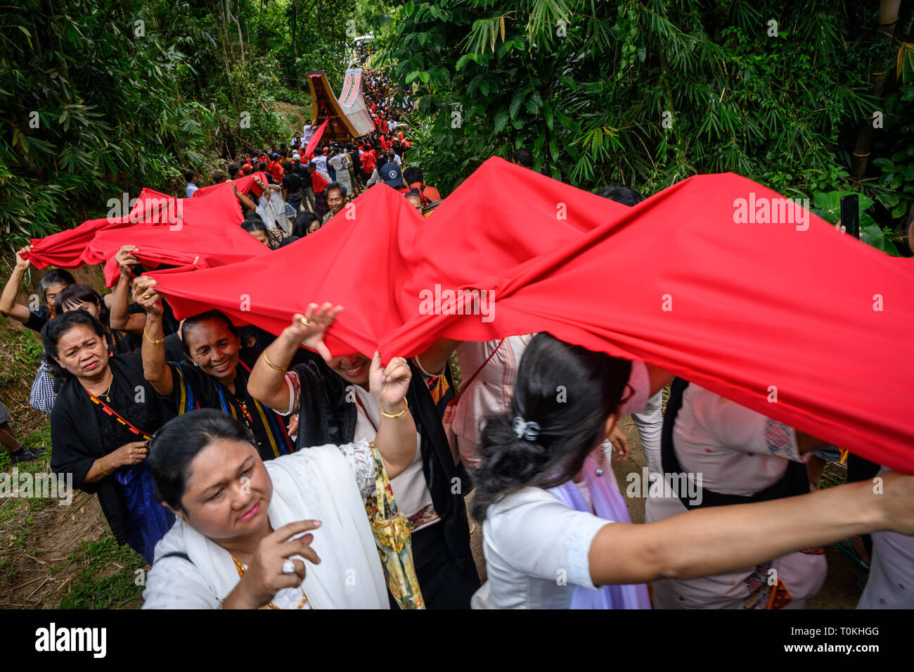 Die Bewohner sind gesehen ziehen rotes Tuch und Särge ihre Verwandten während der Rambu Solo Ritual in Tana Toraja Regency, South Sulawesi. Rambu Solo ist ein Trauerzug für die Tana Toraja Gemeinschaft ihre Vorfahren zu ehren. Die Prozession besteht aus mehreren Veranstaltung Arrangements und dauert mehrere Tage. Stockfoto