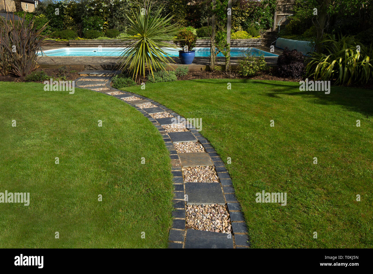 Kies und Stein umrandet Weg über Rasen im Englischen Garten Stockfoto