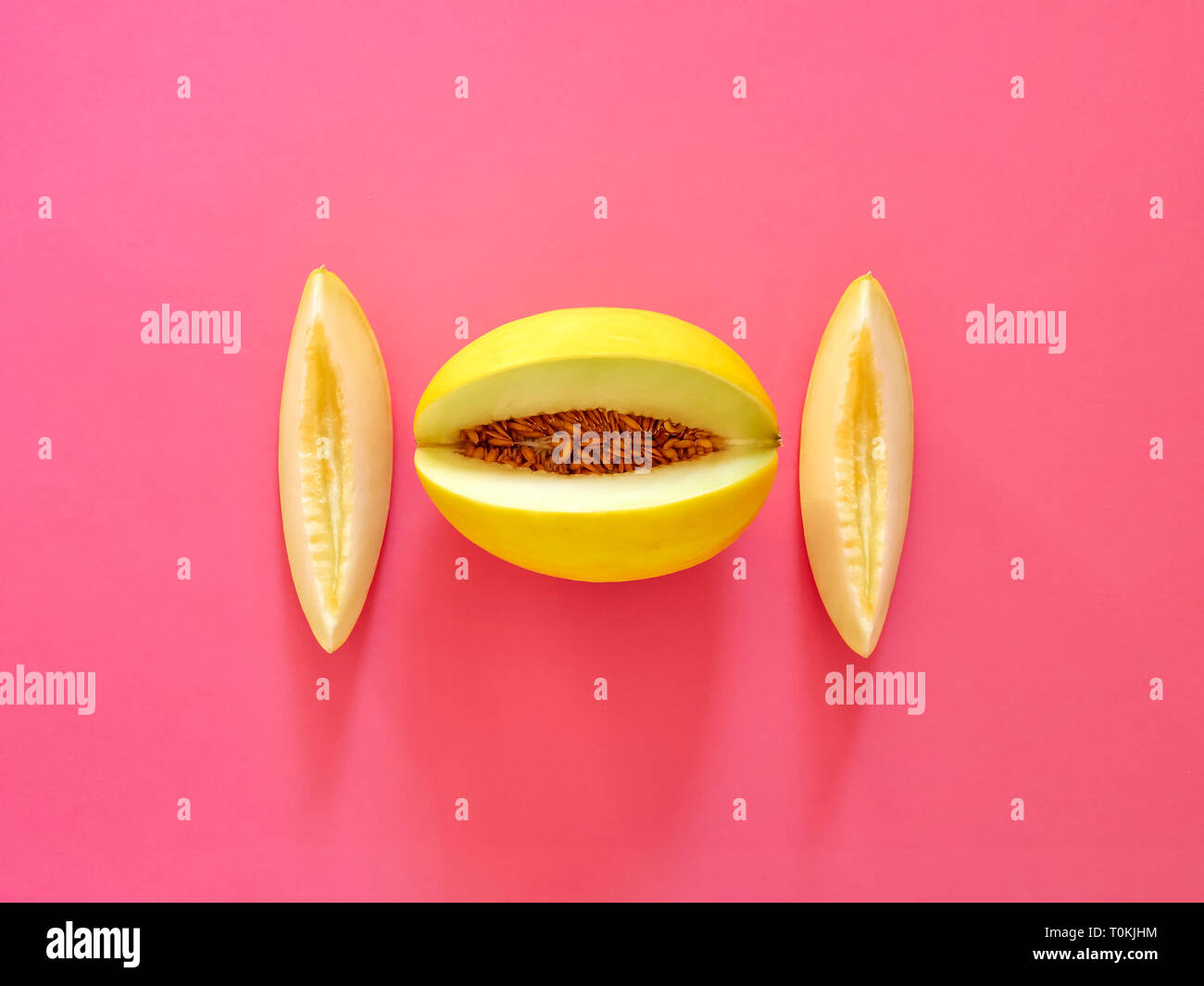 Gelbe Melone Obst isoliert in fucsia Hintergrund von oben betrachtet - flatlay Aussehen - Bild Minimalismus Konzept Stockfoto