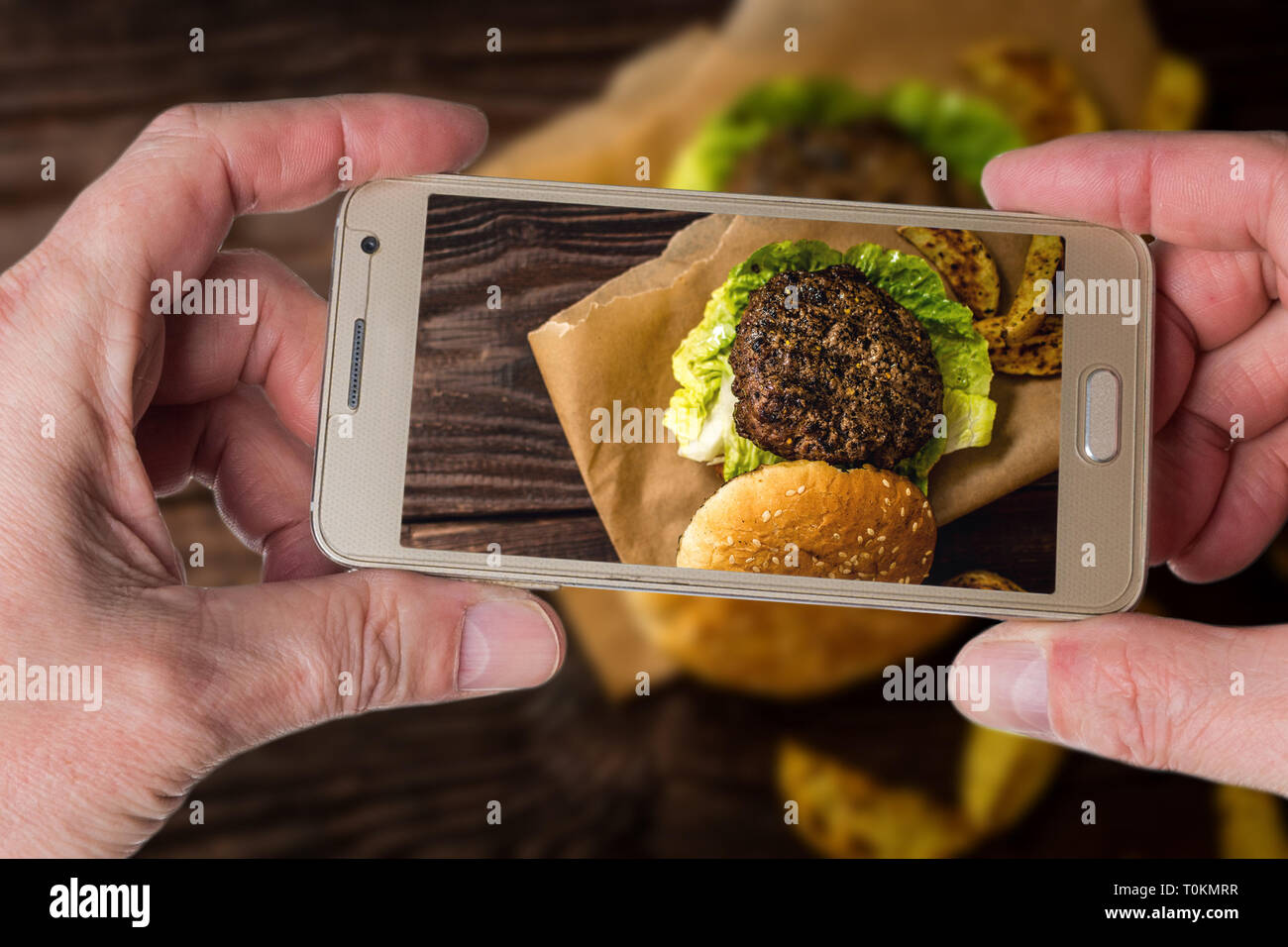 Mann, Foto, gegrilltes Rindfleisch hamburber mit Kartoffel auf Holz Tisch Stockfoto