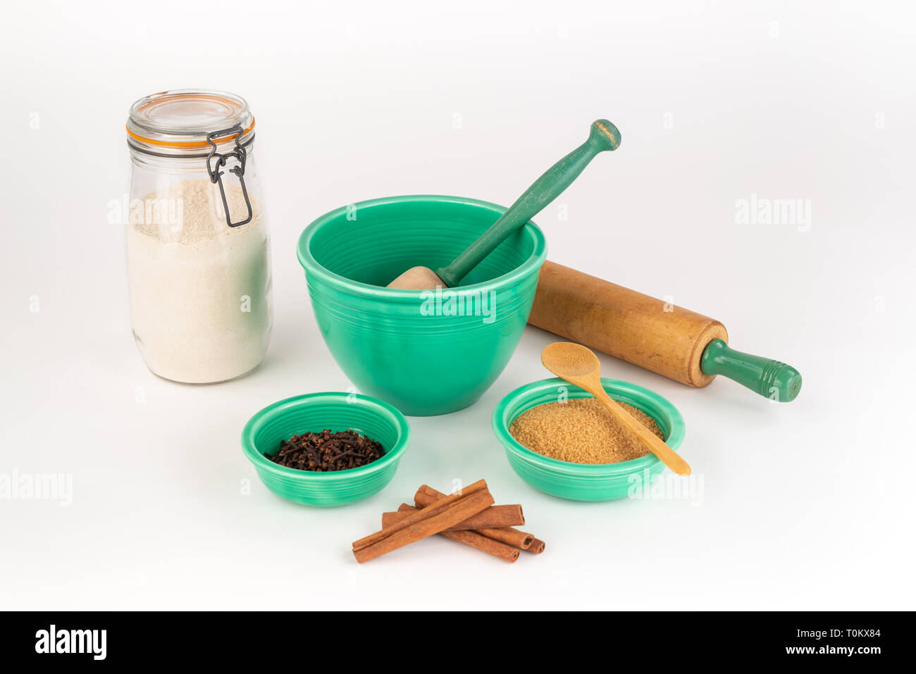 Backzutaten mit Vintage Fiesta Ware Schalen und antiken Nudelholz. Zimt, Bio Zucker, Weizenmehl in Glas. Löffel aus Holz. Stockfoto