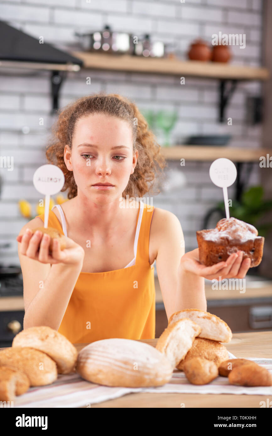 Distressed junge Frau mit Laibe Brot mit beiden Händen Stockfoto