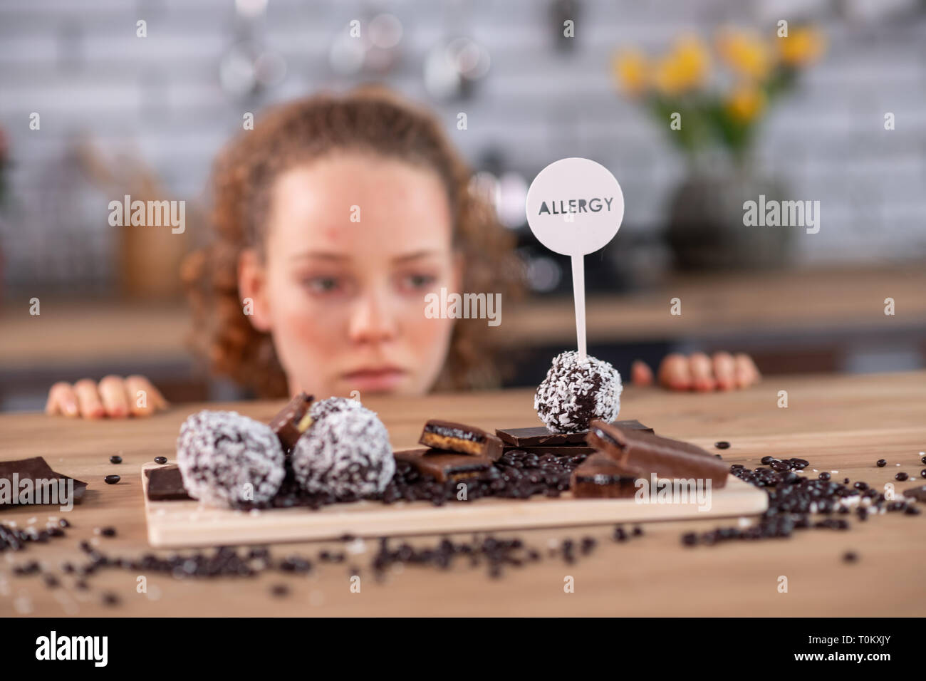 Curly müde - behaarte Frau lehnte sich auf dem Küchentisch berühren Warnung Stockfoto