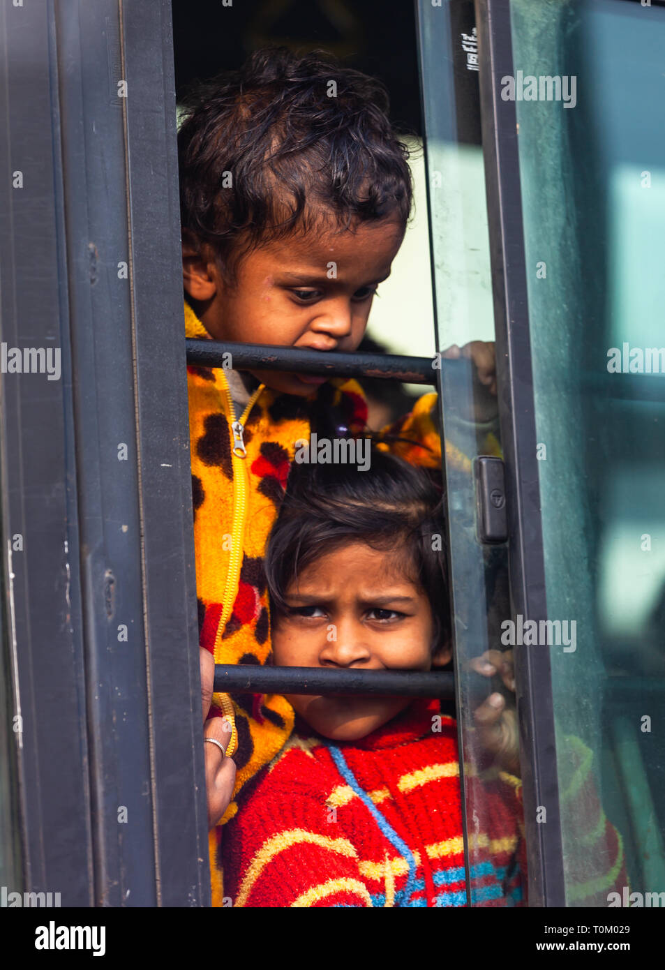 AGRA, INDIEN - November 15, 2012: Indische armen schmutzige Kinder die Fahrt mit dem Zug und schaut aus dem Fenster. Arme und reiche Inder leben Stockfoto