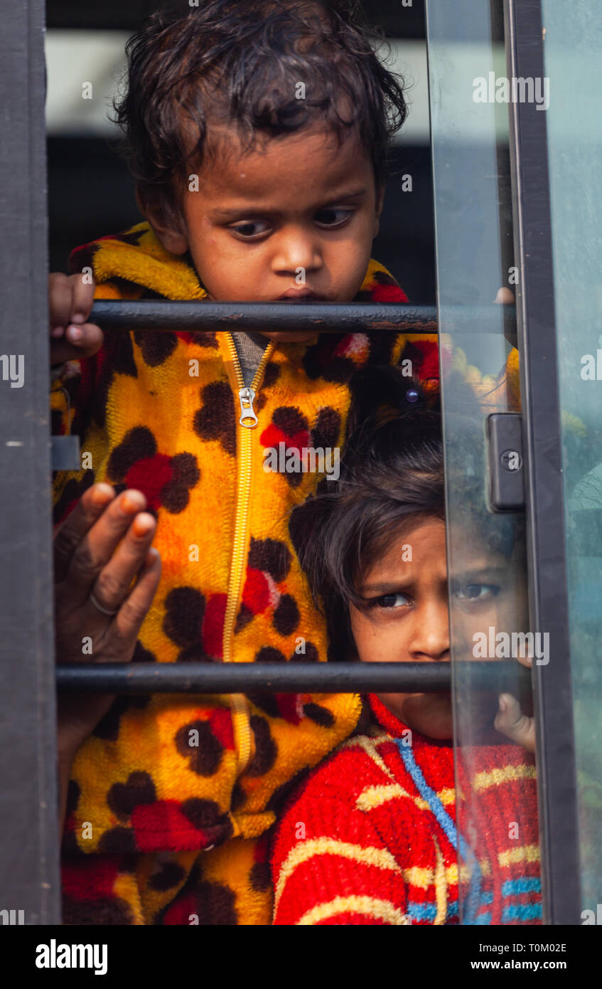 AGRA, INDIEN - November 15, 2012: Indische armen schmutzige Kinder die Fahrt mit dem Zug und schaut aus dem Fenster. Arme und reiche Inder leben Stockfoto