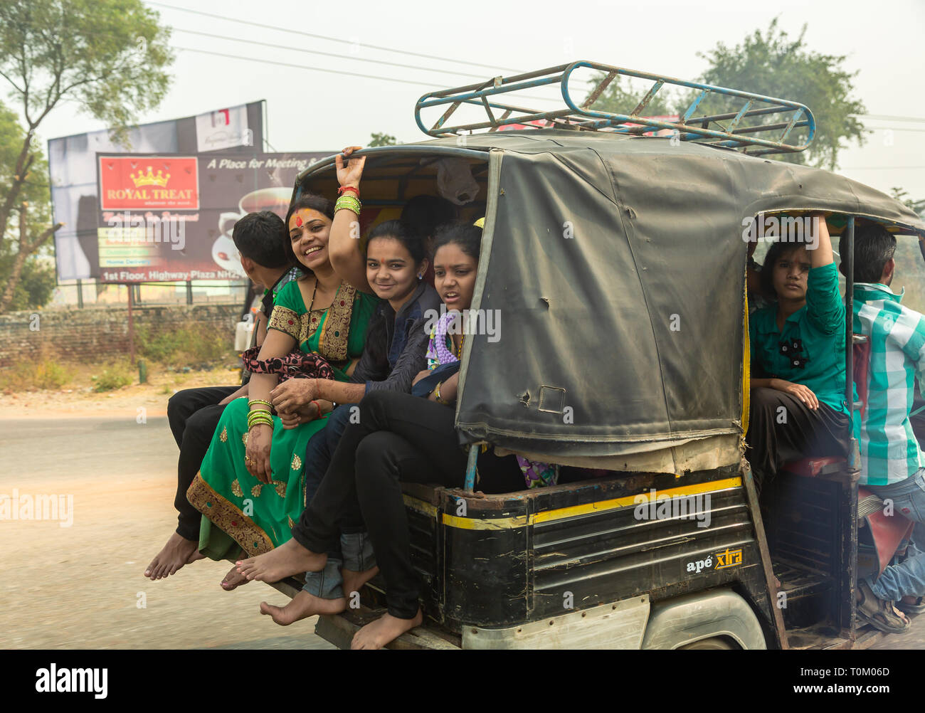AGRA, INDIEN - November 16, 2012: Verkehr auf den Straßen von Indien. Große indische Familien reisen in ein kleines Auto. Indische Menschen und ihre bunten Kult Stockfoto