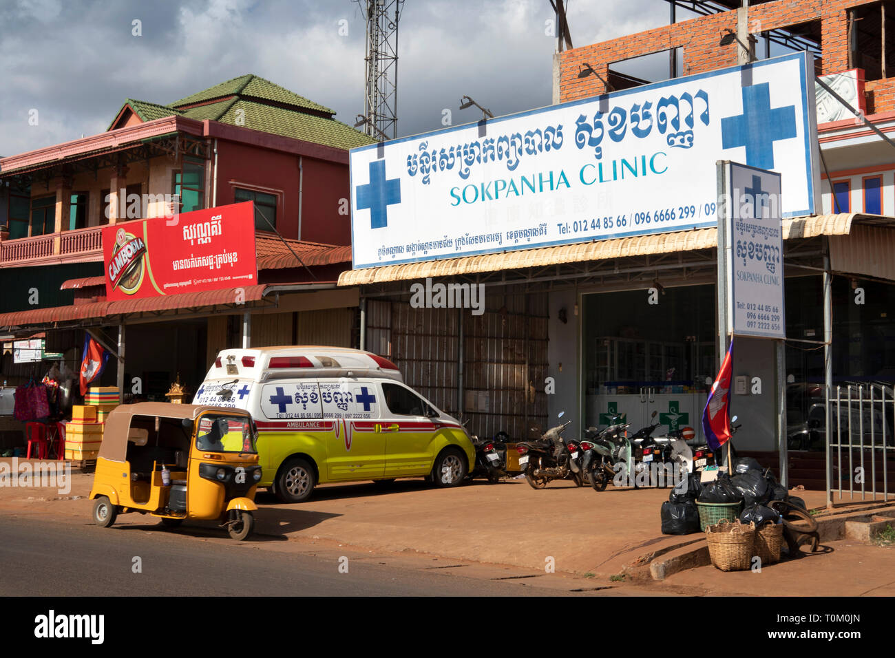 Kambodscha, Provinz Mondulkiri, Sen monorom, Main Street, Ambulanz und Tuk-tuk außerhalb Sokpanha private medizinische Klinik geparkt Stockfoto