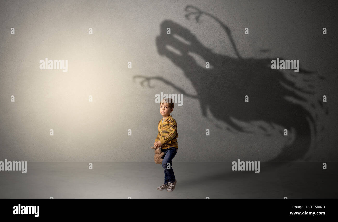 Beängstigend ghost Schatten in einer dunklen leeren Raum mit einem niedlichen blonden Kind Stockfoto