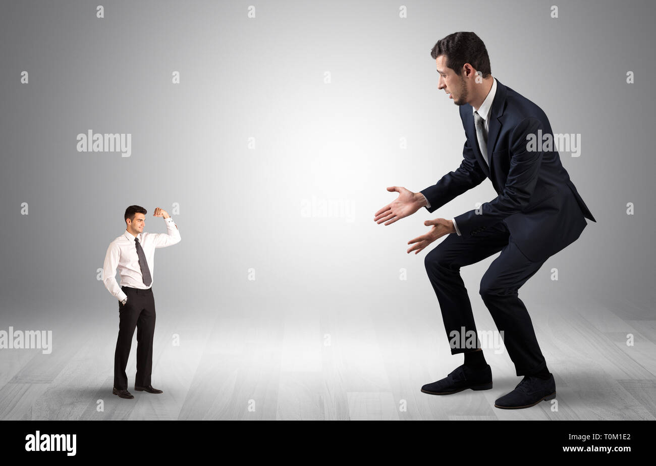 Big debutant junge Unternehmer haben Angst vor kleinen starken Geschäftsmann Stockfoto