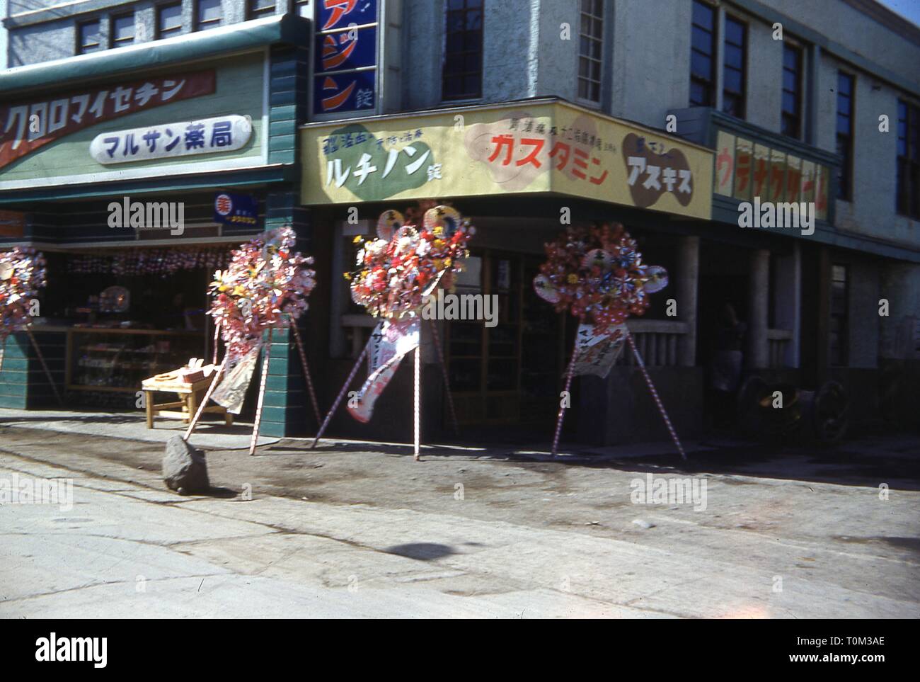 Leicht Froschperspektive von Blumenarrangements auf Stativen, auf dem Bürgersteig außerhalb eines neu eröffneten Store, Sendai, Präfektur Miyagi, Japan, 1952. () Stockfoto