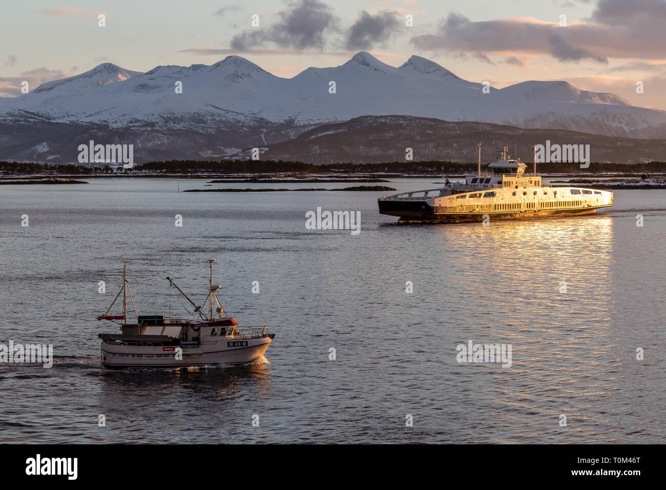 Die norwegische Fähre Fannefjord und ein kleines Fischerboot, außerhalb der Stadt Molde in Norwegen. Stockfoto