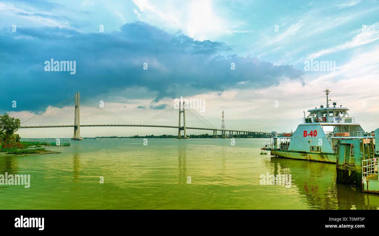 Landschaft Fähre zum Hafen zu verlassen Passagiere über den Fluss Mekong im Frühjahr zu transportieren, weit entfernt ist Cao Lanh Brücke gerade abgeschlossen Stockfoto