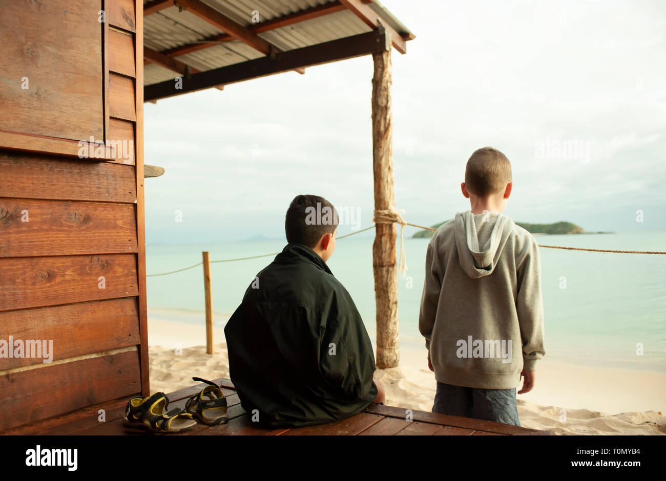 9 Jahr alt und 7 Jahre alten Jungen außerhalb eines Lean Beach Hut auf Putney Strand, Great Keppel Island, Queensland, Australien Stockfoto