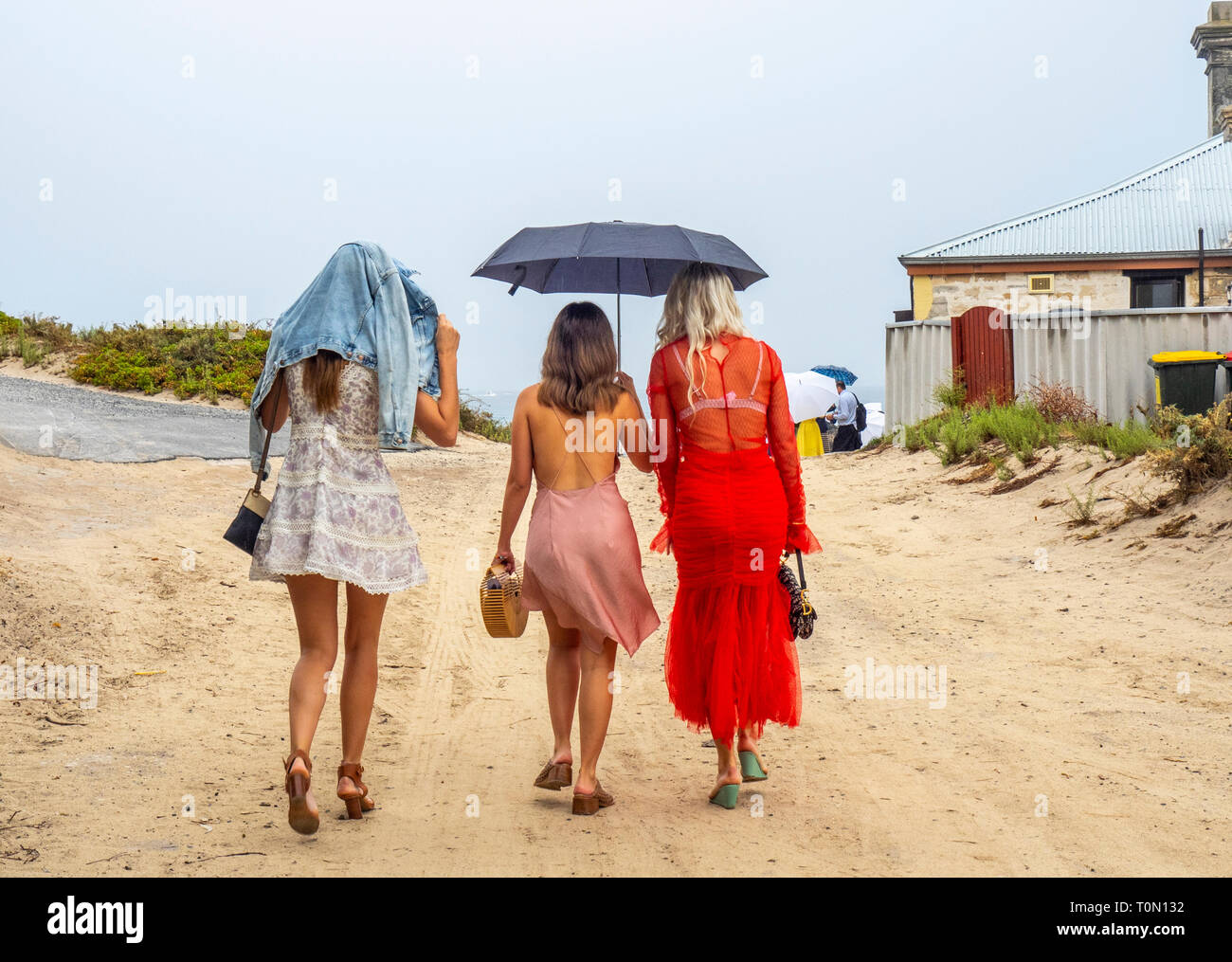 Drei Jungen Damen walking bei leichtem Regen auf Rottnest Island WA Australien. Stockfoto