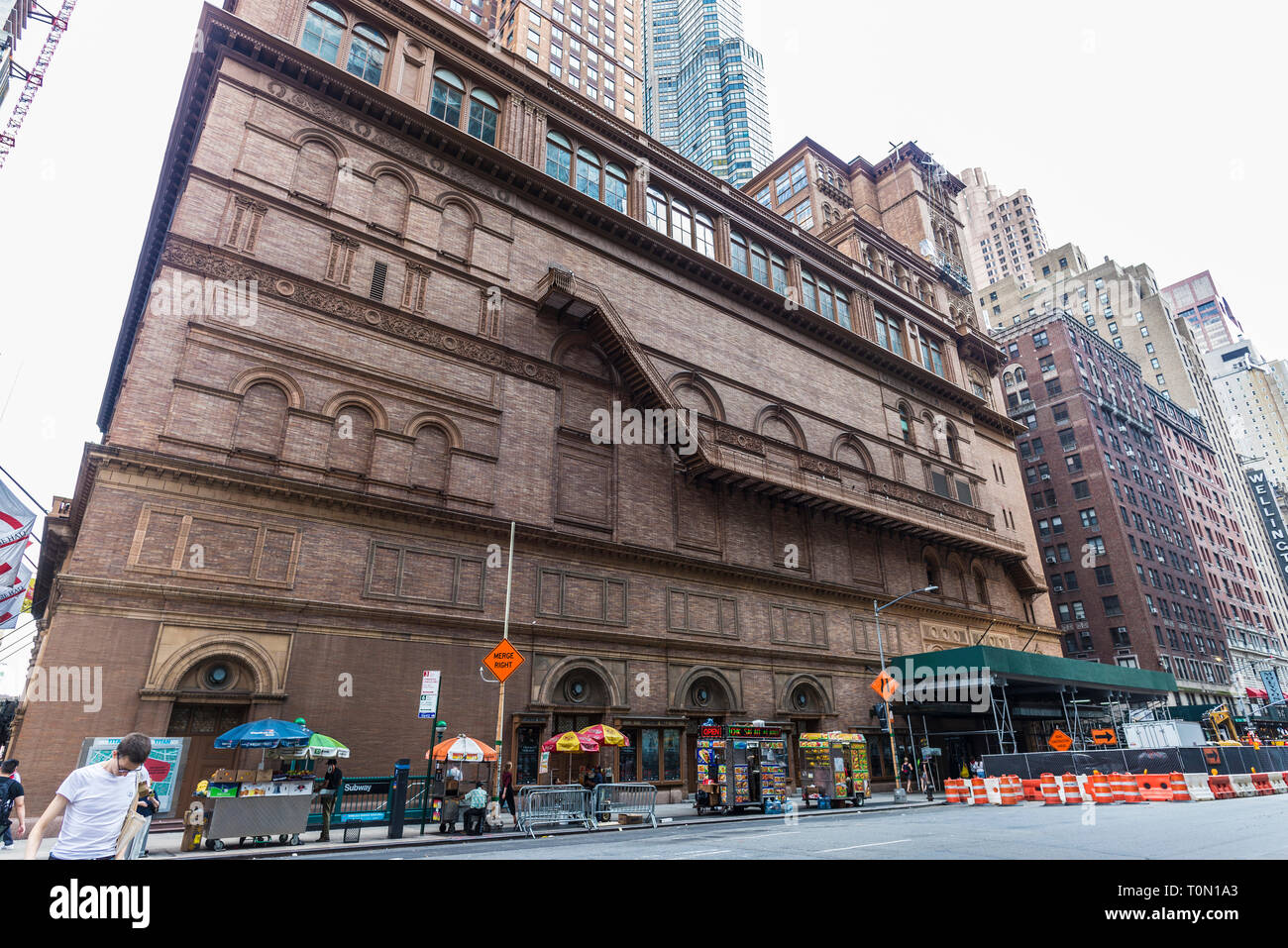 New York City, USA - 28. Juli 2018: Die seitliche Fassade mit ihrer Treppe der Carnegie Hall im 7th Avenue (Seventh Avenue) mit Menschen um in Midtow Stockfoto