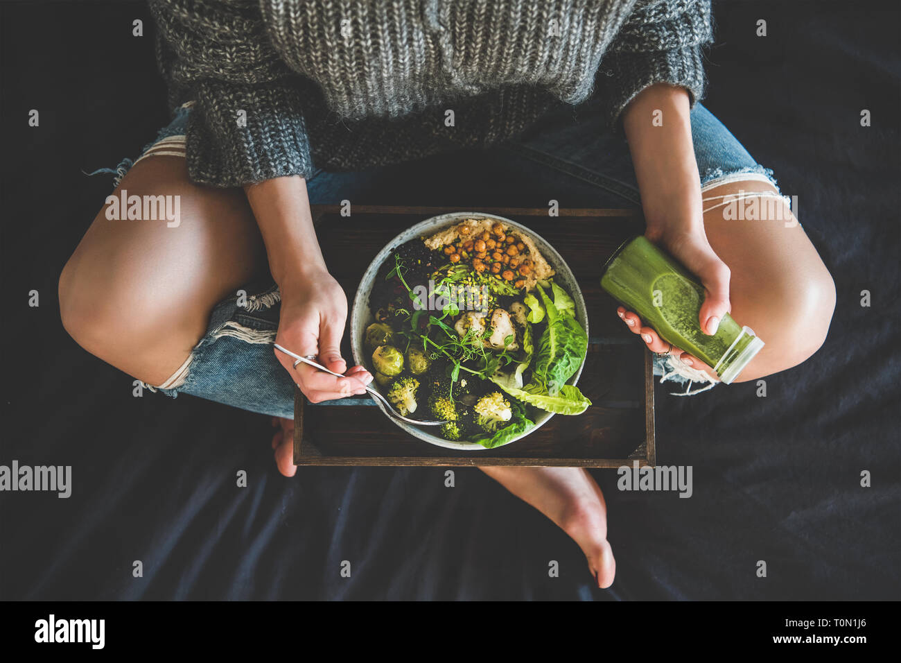 Frau im Bett essen Vegan essen und trinken Smoothie Stockfoto