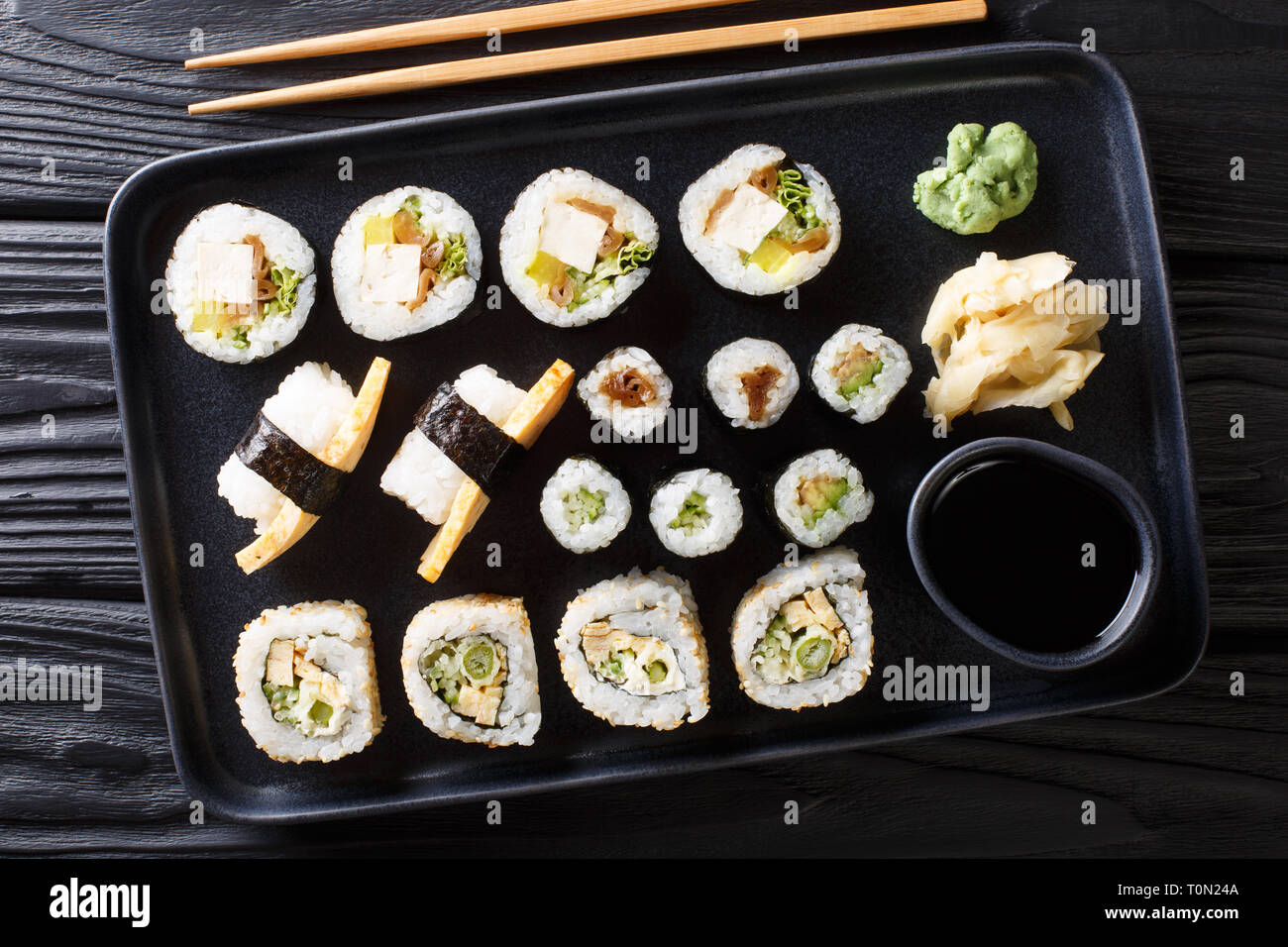 Köstliche japanische Sushi Rollen große mit Meeresfrüchten, Gemüse, Tofu und tamago Closeup auf einem Teller auf den Tisch gesetzt. horizontal oben Ansicht von oben Stockfoto