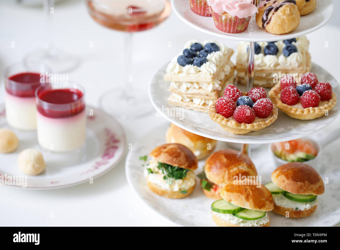 Nachmittagstee mit Mini brioche Kanapees und Auswahl an Süßigkeiten Stockfoto