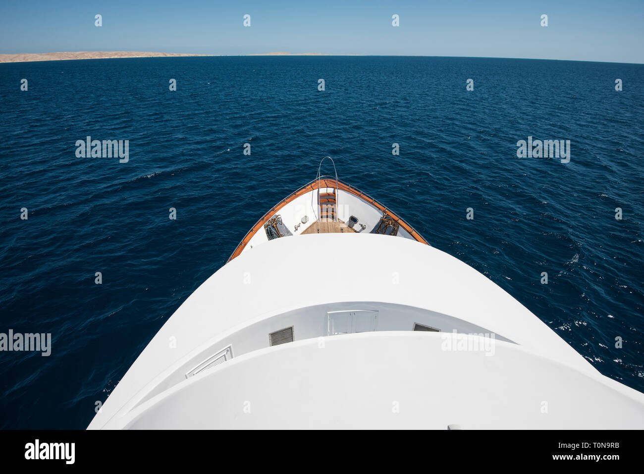 Blick über den Bug eines großen Luxus Motoryacht auf tropischen Meer mit Ankern Stockfoto