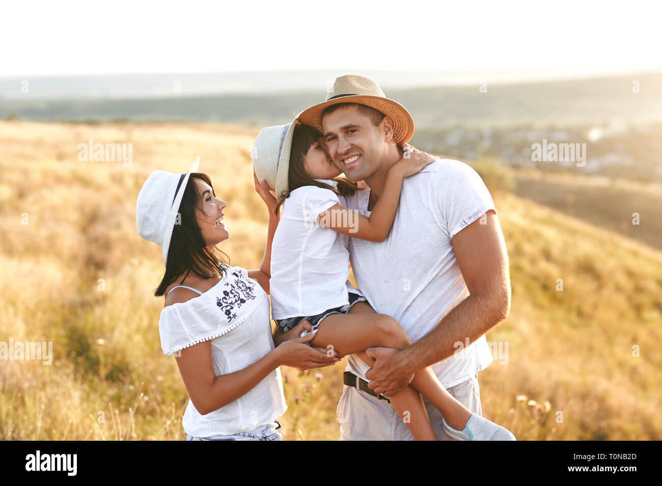 Stilvolle glückliche Eltern mit Mädchen in der Landschaft Stockfoto