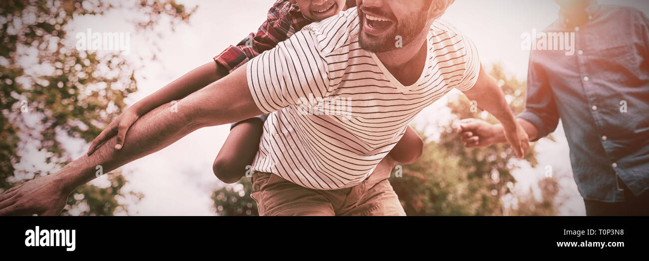 Gerne Großvater bei Mann, piggy Backing zu Sohn gesucht Stockfoto