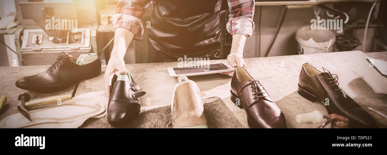 Schuster mit einem Tabletcomputer Stockfoto