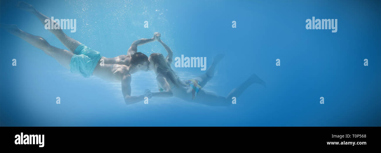 Süßes Paar Hand in Hand unter Wasser im Schwimmbad Stockfoto