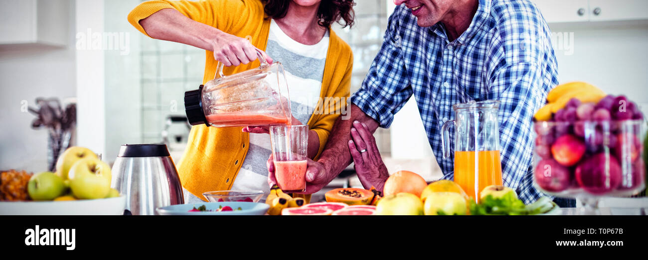 Glückliches Paar Vorbereitung Smoothie in der Küche Stockfoto