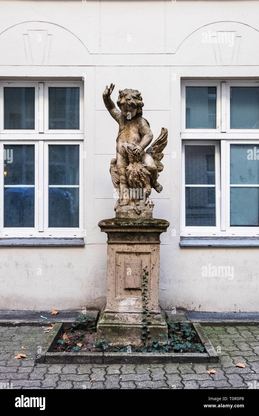 Skulptur des kleinen Kindes auf der Rückseite der Adler auf Sockel im Innenhof des Gebäudes in der Rankestrasse, Berlin Stockfoto