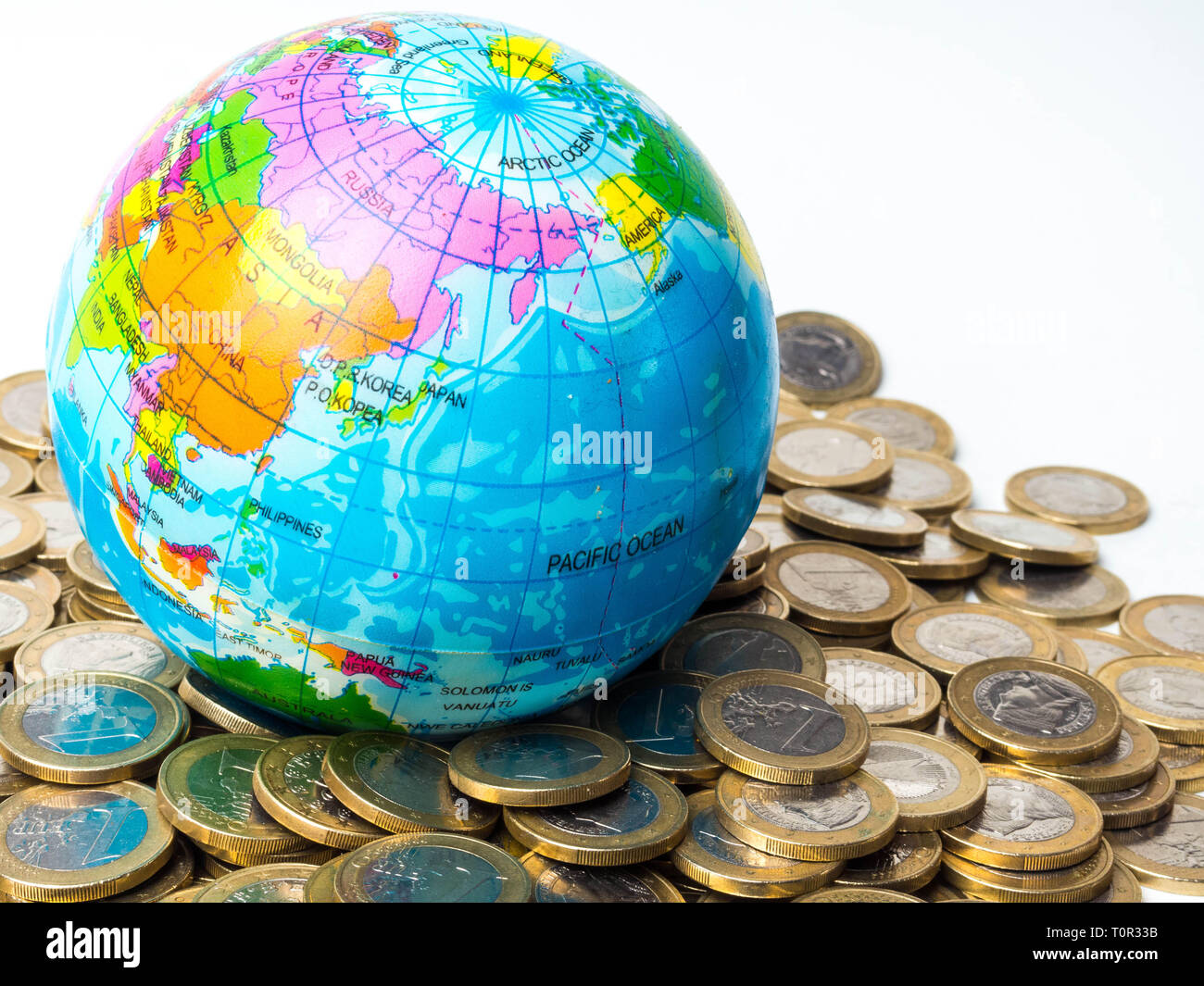 Stapel von Münzen mit Welt Planet auf dem Hintergrund - Begriff der Rettung des Planeten, Konzept der Beziehung zwischen Geld, Wirtschaftswachstum und Planeten ea Stockfoto