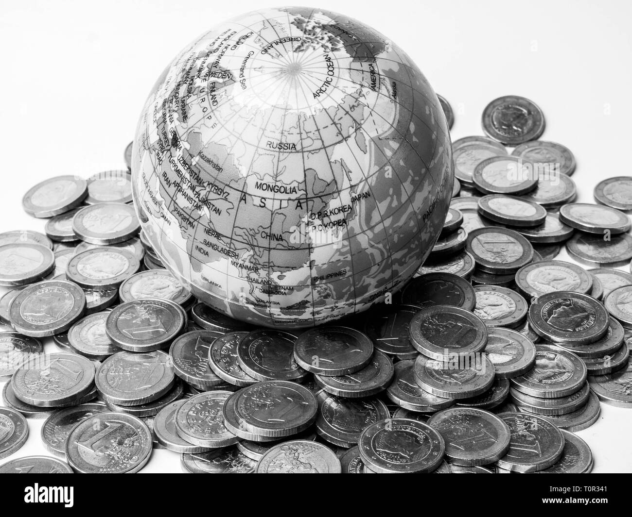 Stapel von Münzen mit Welt Planet Erde Schwarzweiß-Konzept zur Rettung des Planeten, Konzept der Beziehung zwischen Geld, Wirtschaftswachstum Stockfoto