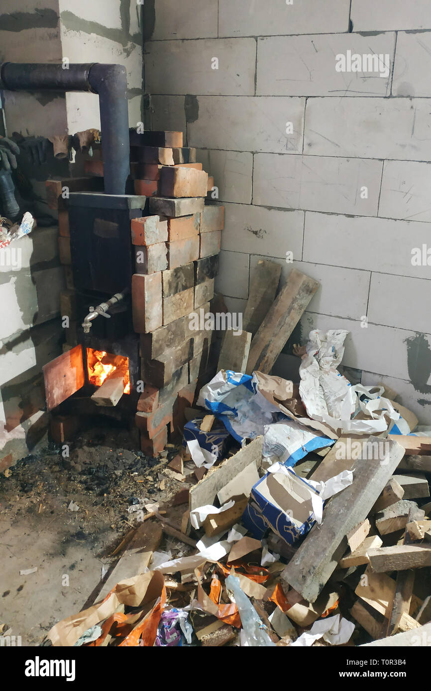 Der Holzofen brennt mit offenen Türen in der Verletzung der stellt eine Gefahr für das Gebäude durch den Brand ein Brand 2019 Stockfoto