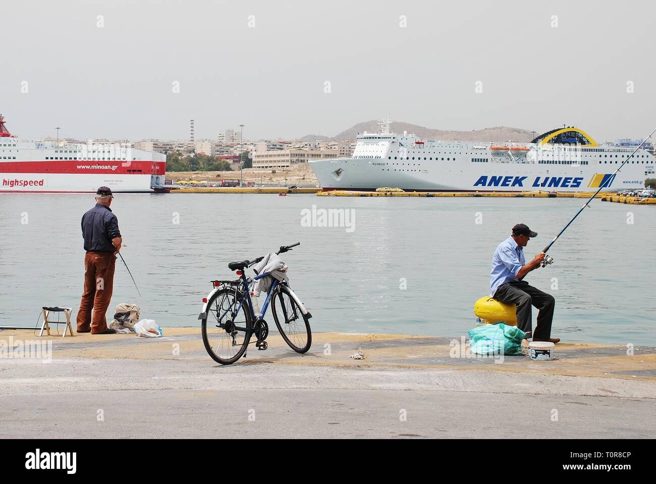 Zwei männliche angler angeln am Hafen von Piräus in Athen, Griechenland, 11. Mai 2016. Piräus ist der größte Hafen Europas. Stockfoto