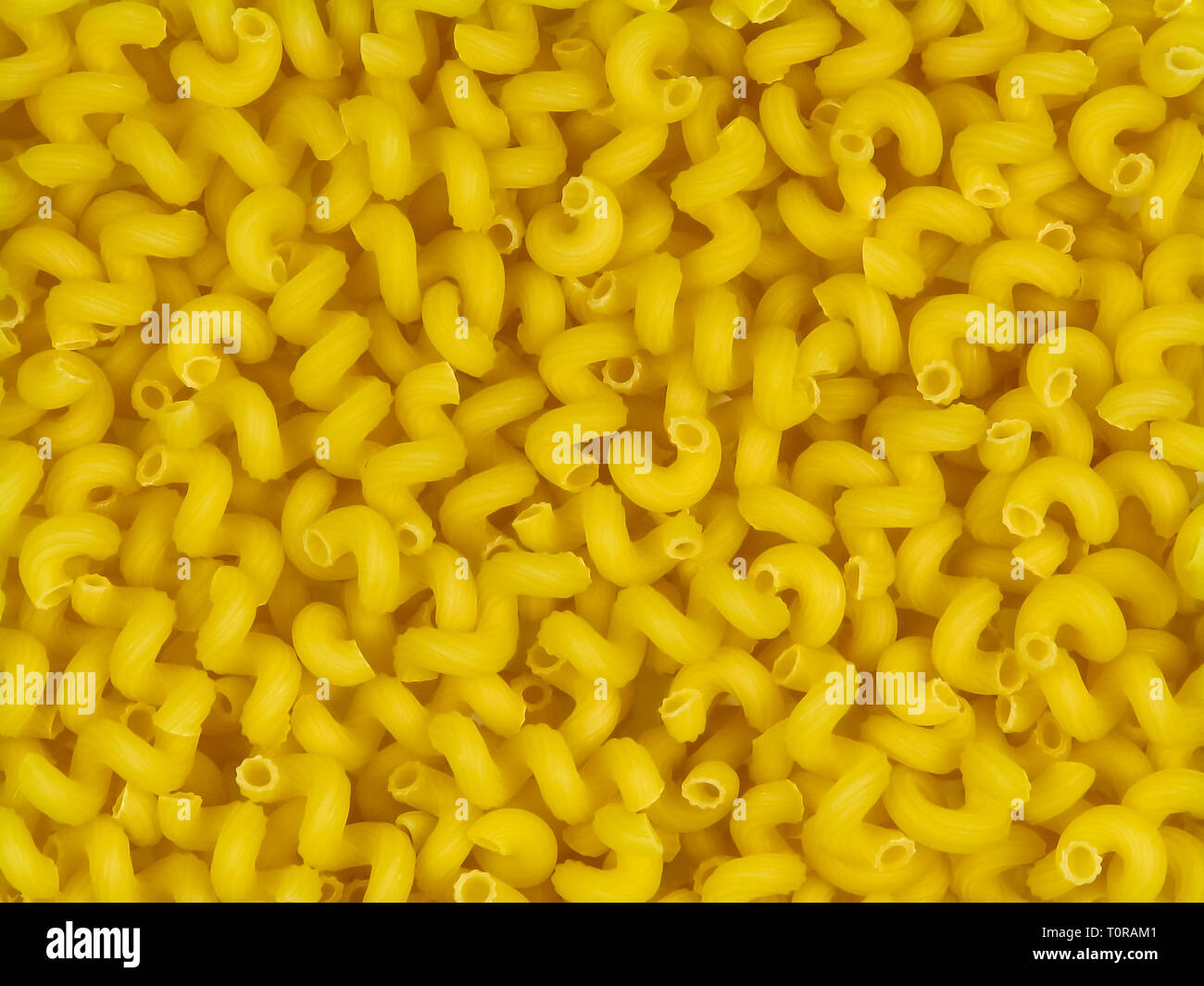 Ungekocht gelb italienische Pasta stortelli zufällige Textur Top View close-up Stockfoto