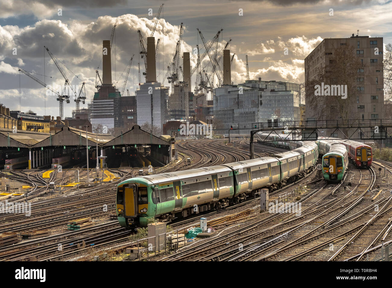Southern Rail Zug nähert sich Ebury Bridge auf der letzten Annäherung an Victoria Station, mit Battersea Power Station in der Ferne, London, Großbritannien Stockfoto