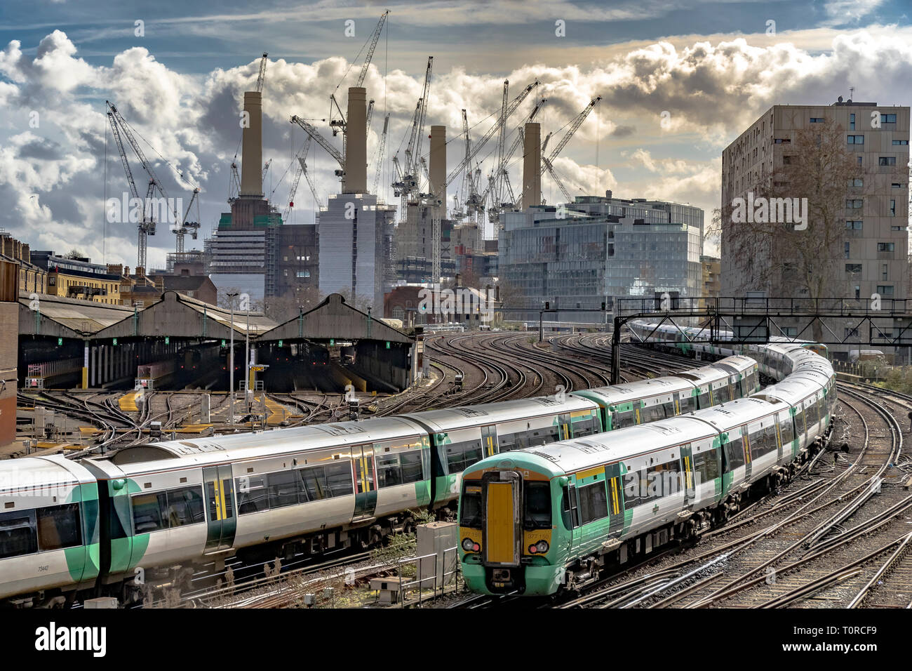 Southern Rail Zug nähert sich Ebury Bridge auf der letzten Annäherung an Victoria Station, mit Battersea Power Station in der Ferne, London, Großbritannien Stockfoto