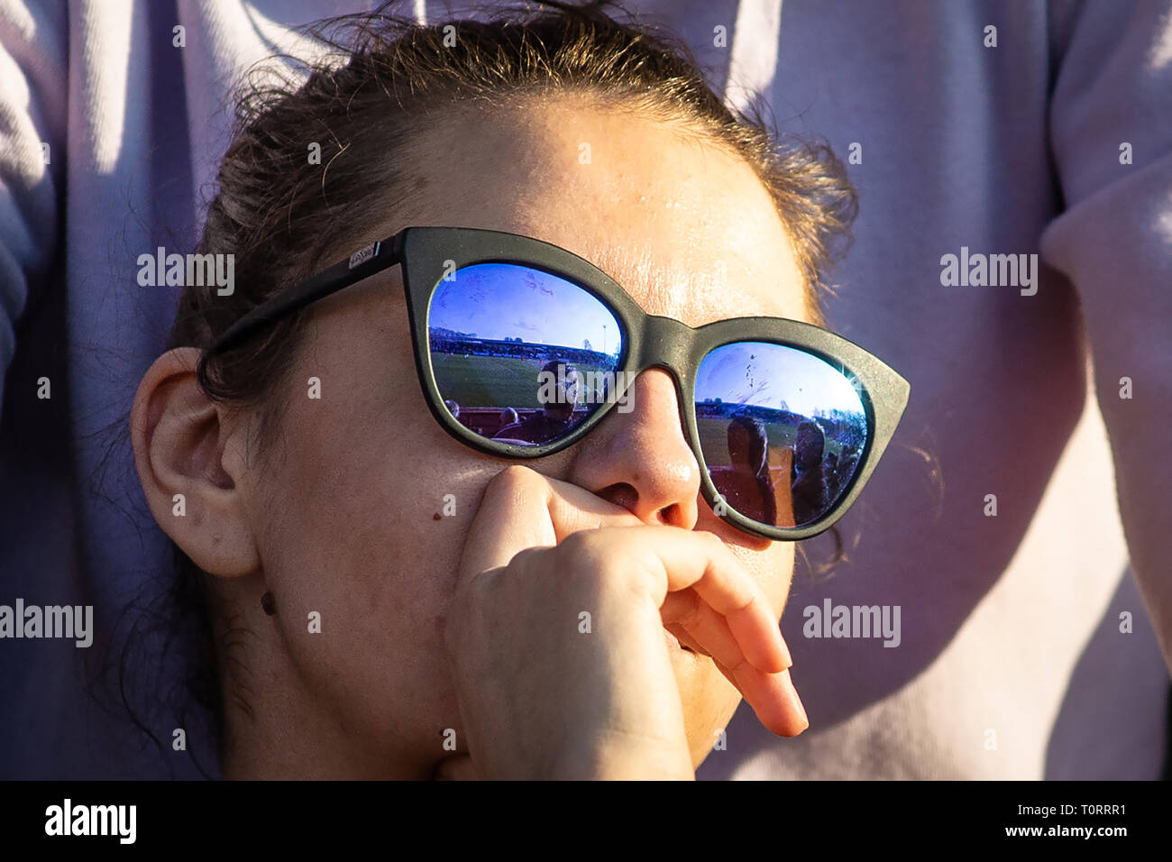 Weibliche Fußball-Ventilator Sonnenbrillen tragen, gerade aus, die auf der Terrasse und schaut nachdenklich. Stockfoto