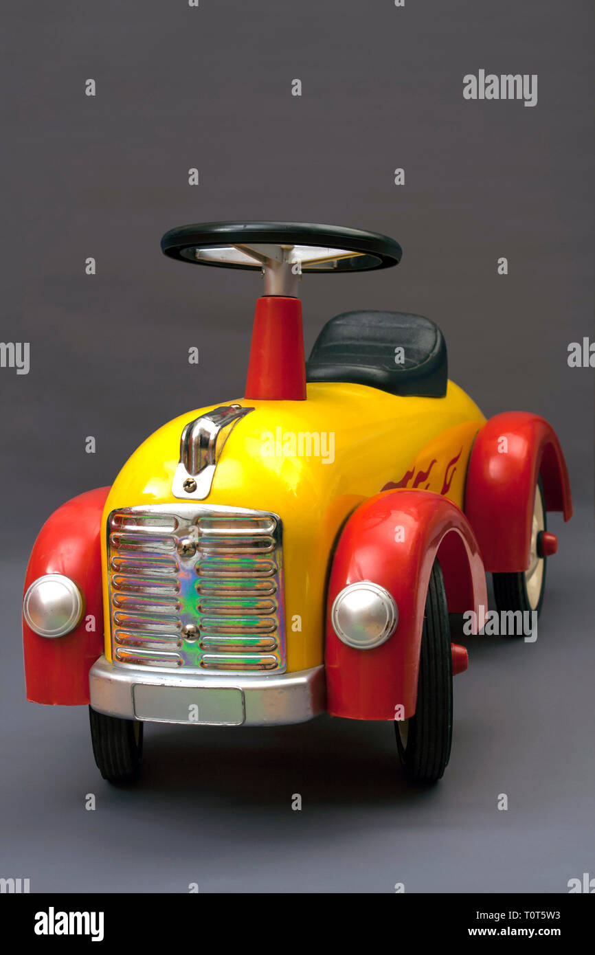 altes Spielzeugauto auf grauem Hintergrund Stockfoto