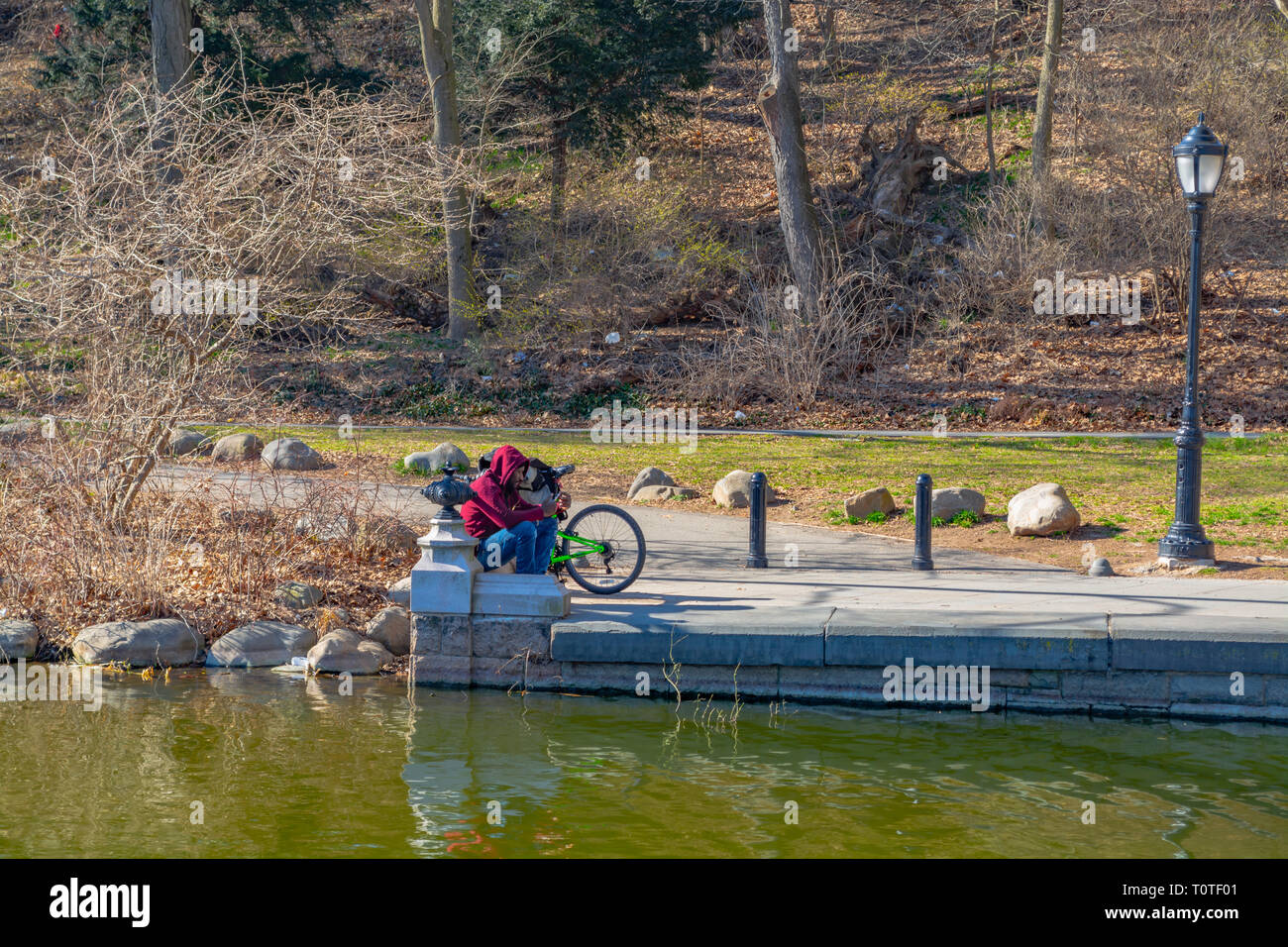 Man sitzt im Park mit seinem Fahrrad in der Nähe, Denken über etwas. Brooklyn, NY Frühjahr 2019 Stockfoto
