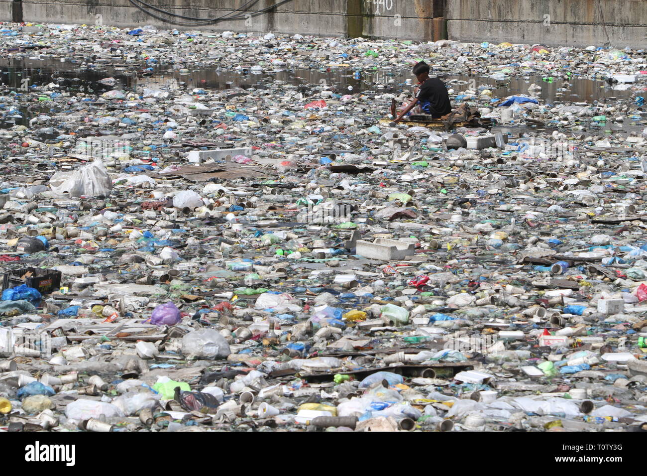 Eine Art Schnitzeljagd sammelt recyclingfähige Materialien, die junkshops verkauft werden können, in Ihrer behelfsmäßigen Floß auf dem Wasser eines Flusses in Manila, Philippinen. Stockfoto