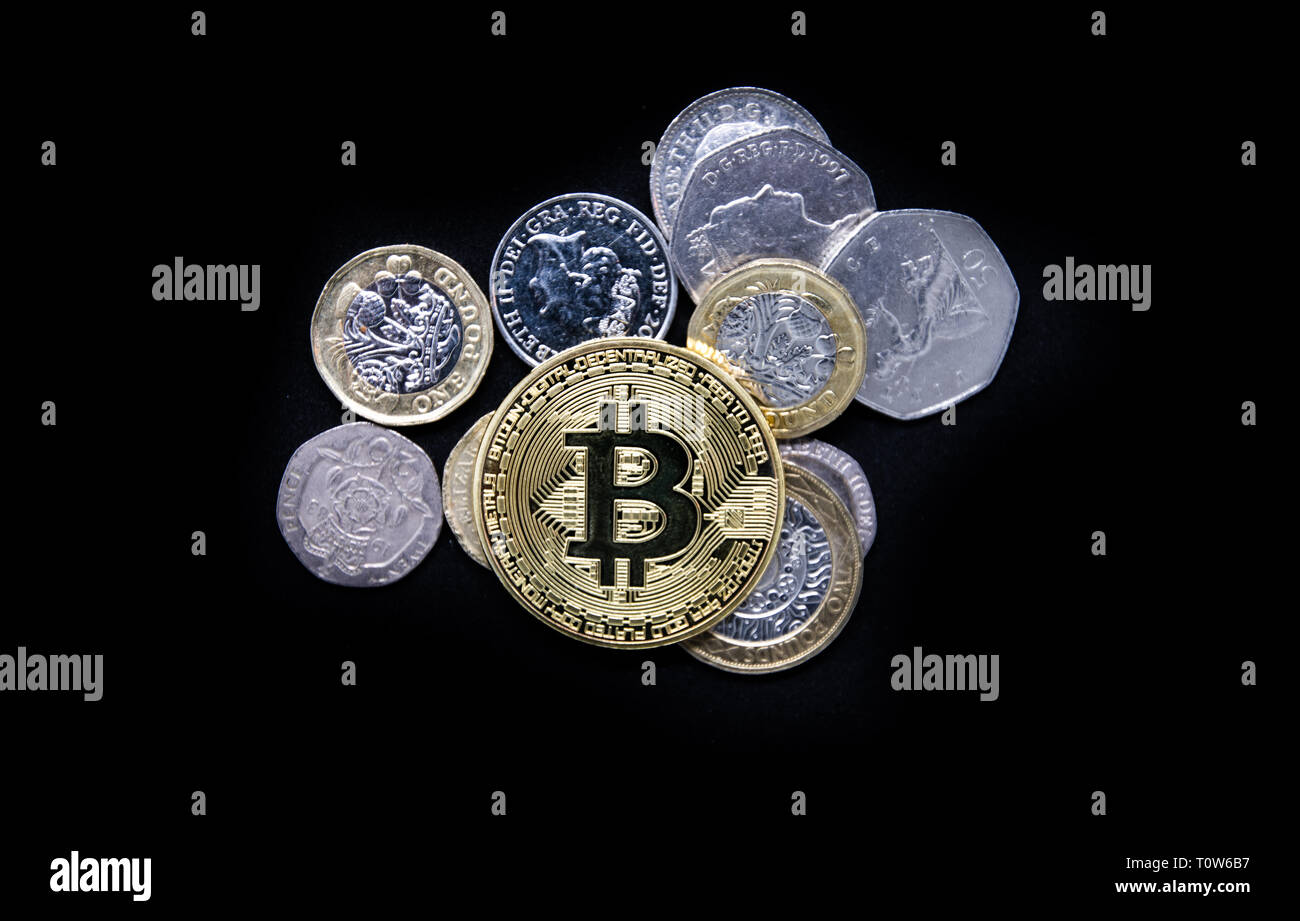 Physisches Gold Bitcoin auf normales altes englisches Geld Stockfoto